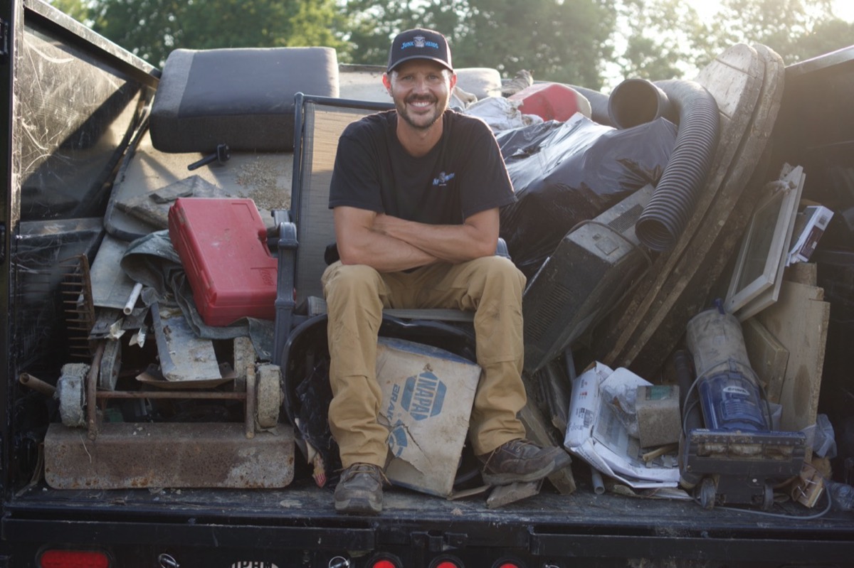 Mark Wilson, owner of Junk Heads, sitting on a full load in the dump trailer